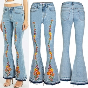 Streetstylejeans med vintageblommig brodyr, vida ben och frasig fåll i mellanhög midja
