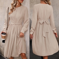 Elegant, enfärgad klänning med rund hals och rynkad långärmad design, självknut i midjan och plisserad detalj.