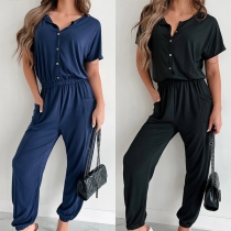 Casual jumpsuit med enfärgad design, rund hals och resår i midjan, med patchfickor
