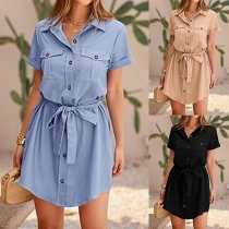 Casual solid color dress with patch pockets, stand collar, short sleeves, and self-tie.