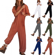 Casual jumpsuit med enfärgad design, rund hals och armbågeärm, försedda med fickor med patch.