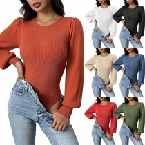 Moderiktig enfärgad ribbad body med rund hals och långärmad design