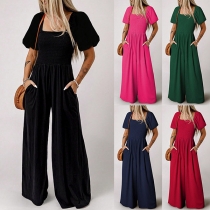 Kortärmad jumpsuit med fyrkantig hals och smockad midja, rak skuren