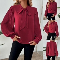 Moderiktig blus med rosett och plisserade ballongärmar