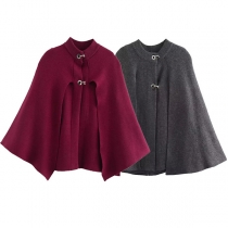 Elegant enfärgad stickad poncho med spänne