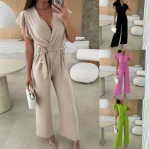 Enfärgad V-ringad kortärmad jumpsuit med volanger och självknuten design