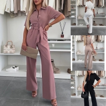 Moderiktig enfärgad jumpsuit med ståkrage och korta ärmar, framknäppt och rak skärning