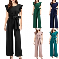 Ärmlös jumpsuit i enfärgad design med volanger, rund halsringning och knytbar midja