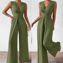 Elegant jumpsuit utan ärmar i enfärgad design med V-ringning, korsad midja och vida byxben