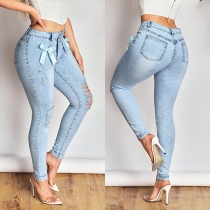 Skinny jeans med asymmetrisk midja, rosett och slitna detaljer