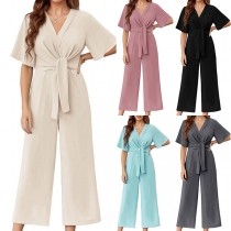 Kortärmad damjumpsuit med V-ringning, midjerosett och vida ben