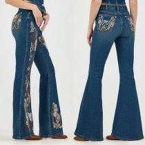 Jeans i slim fit med blombroderier och utsvängda ben