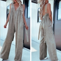 Denimjumpsuit med djup V-ringning, öppen rygg, vida ben och sidofickor i vintage-tvätt