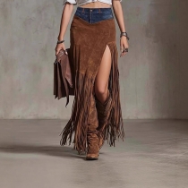 Dam denimmaxikjol med skarvade sidoslitsar och tofsdetaljer i fållen