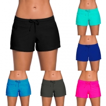 Moderiktiga enfärgade badshorts med låg midja