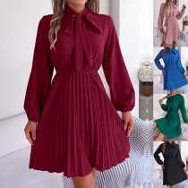 Enfärgad plisserad klänning med långa ärmar, självknutande mock neck - i modetrend