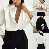 En minimalistisk och enfärgad blus med fyrkantiga axlar och långa ärmar